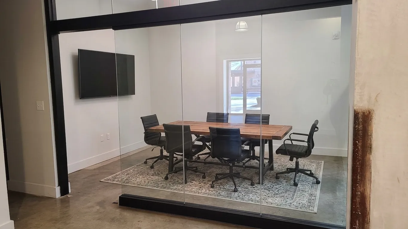 Glass-walled conference room in Suite 120C at Drayton Mills