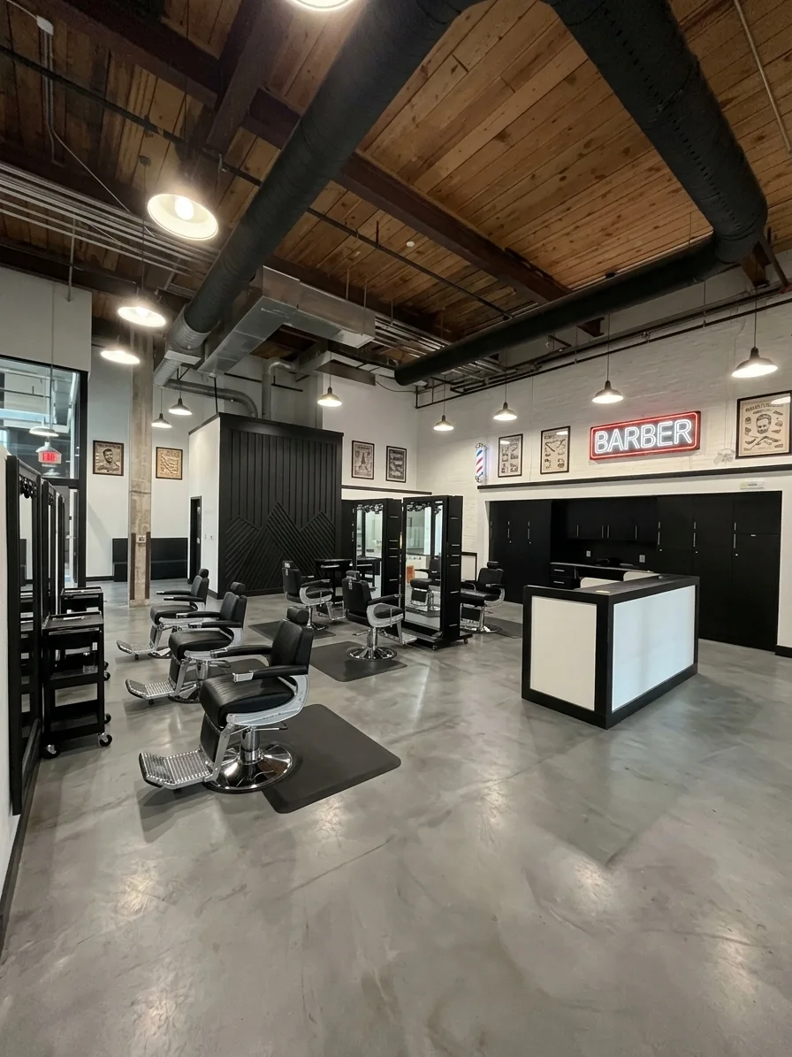 Barbershop build-out with barber chairs and a neon BARBER sign, representing Suite 120D at Drayton Mills